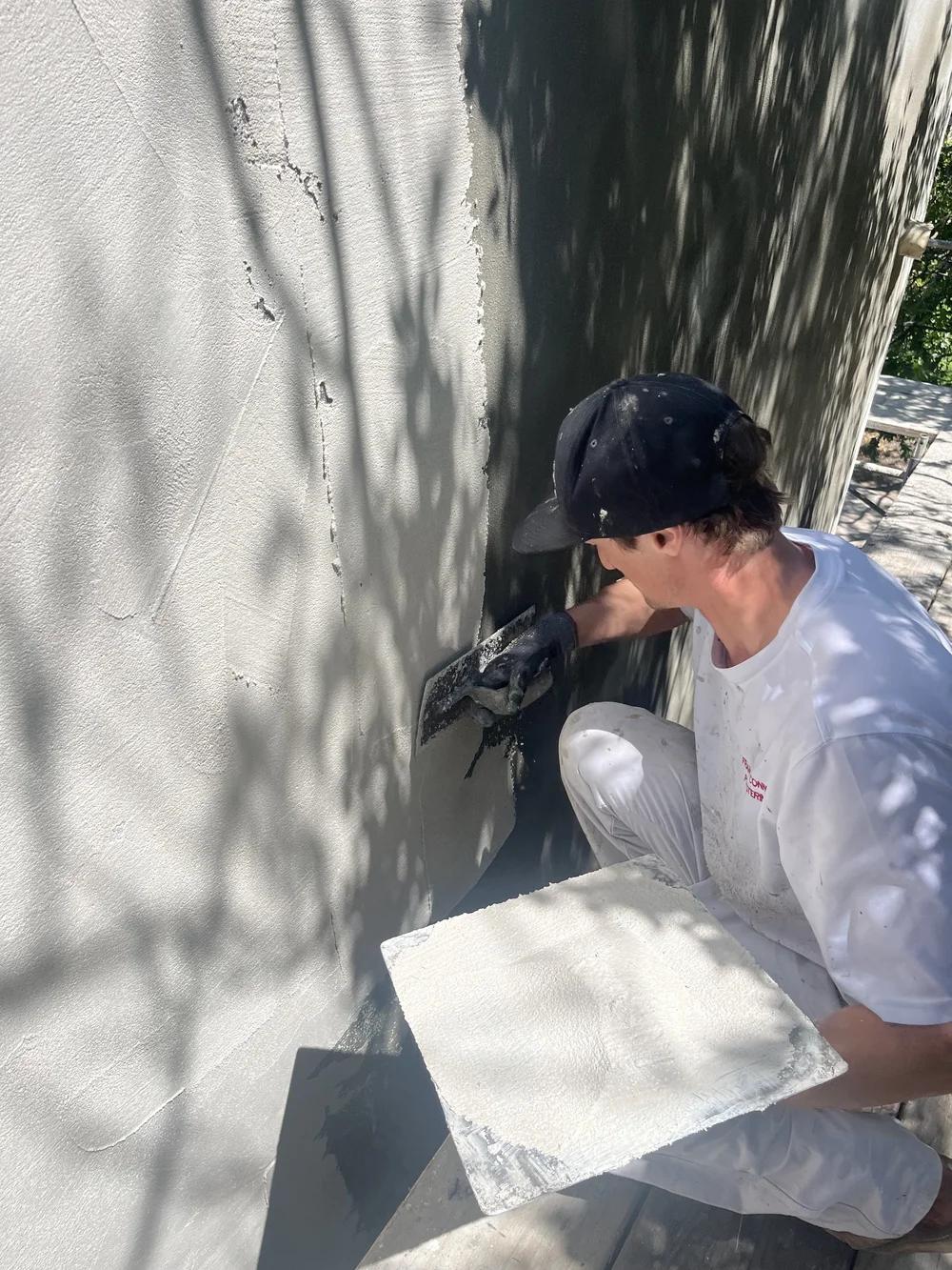 Preston applying plaster by hand